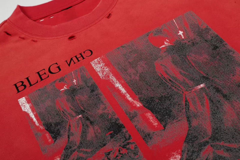 Red distressed graphic tee with faded black print and a vintage-style abstract portrait on the chest