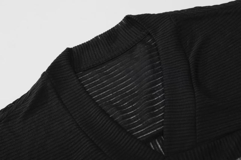 Close-up of black ribbed V-neck shoulder seam and sheer textured fabric