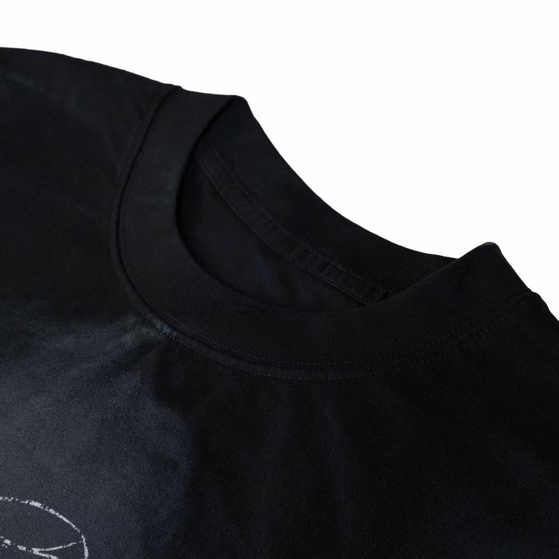Black distressed graphic tee with washed finish and ribbed crew neckline, shown in close-up detail