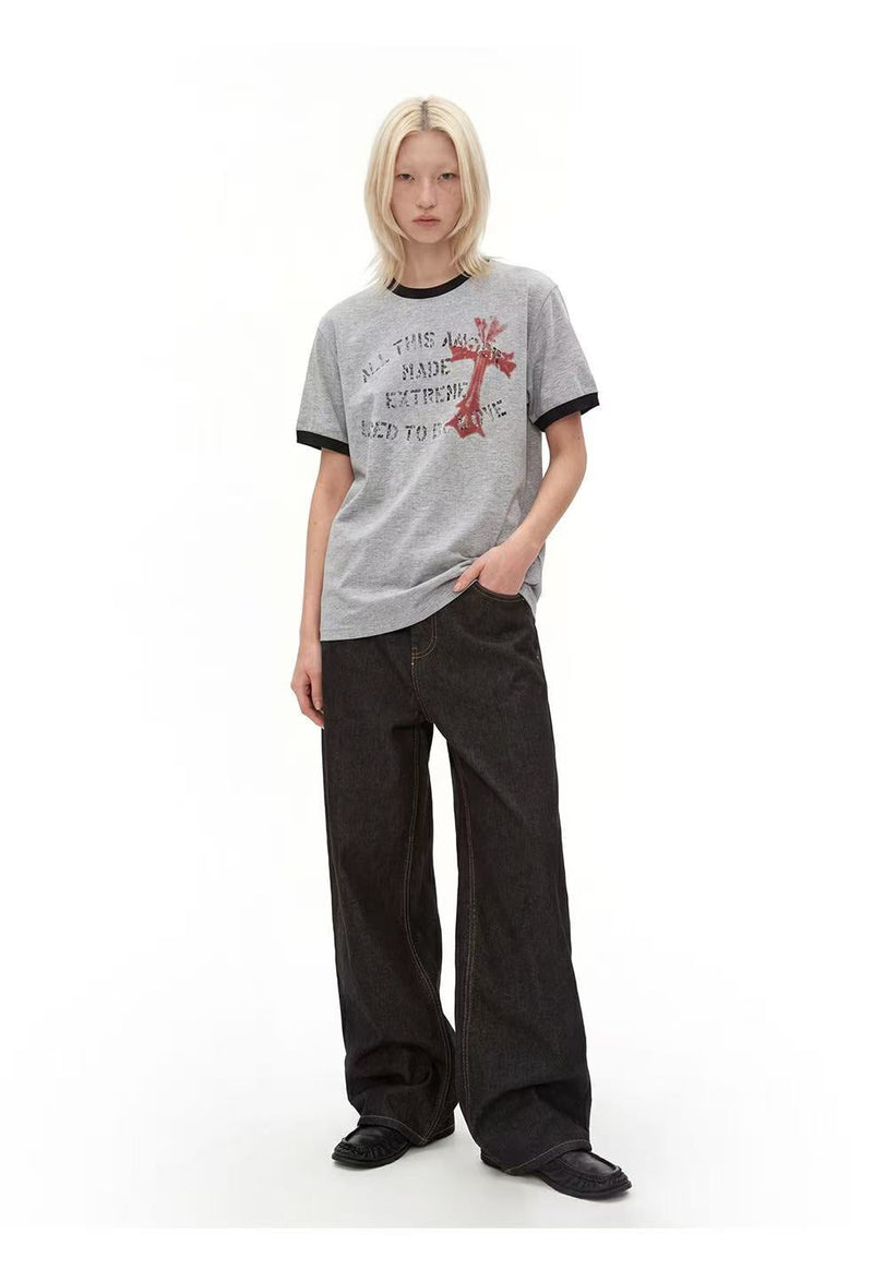 Gray ringer T-shirt with black trim and distressed cross graphic worn with wide-leg black jeans