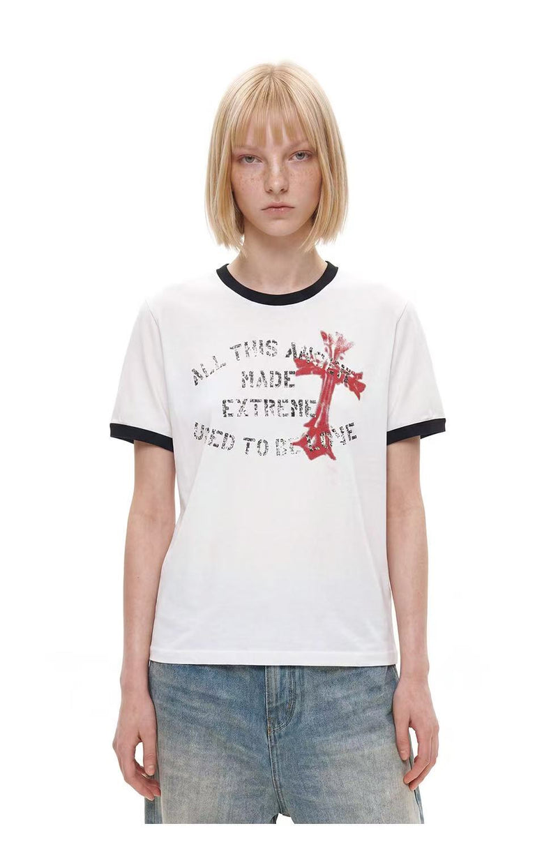 White ringer T-shirt with black trim, distressed cross graphic, and faded streetwear-style text print on the chest