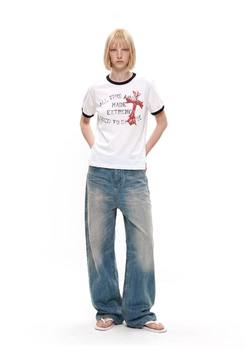 White ringer T-shirt with black trim, distressed cross graphic print, and relaxed streetwear fit on model