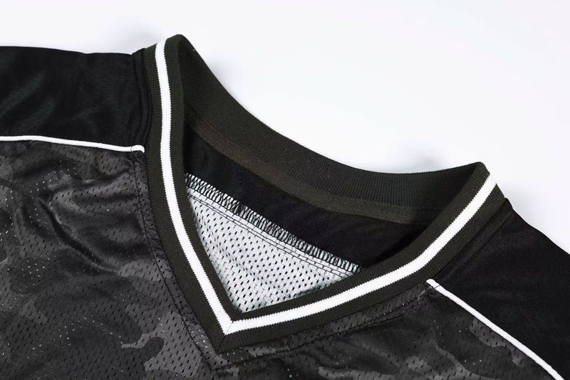 Close-up of a dark camo mesh athletic jersey with white trim and ribbed V-neck collar