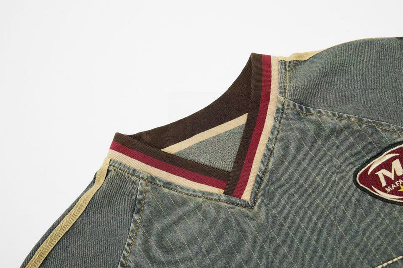 Vintage denim sport tee with striped ribbed collar and embroidered chest patch on a washed blue-green streetwear shirt