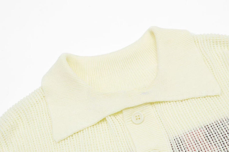 Close-up of a cream varsity knit polo collar with textured mesh fabric and button detail