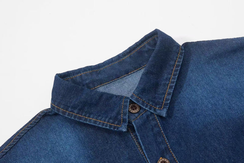Close-up of a blue denim button-up shirt collar with contrast stitching and a visible front button