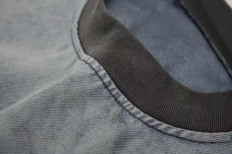 Close-up of a vintage washed distressed T-shirt neckline with ribbed collar and faded gray fabric texture