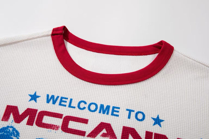 White ringer T-shirt with red collar and blue and red vintage McCann band graphic print