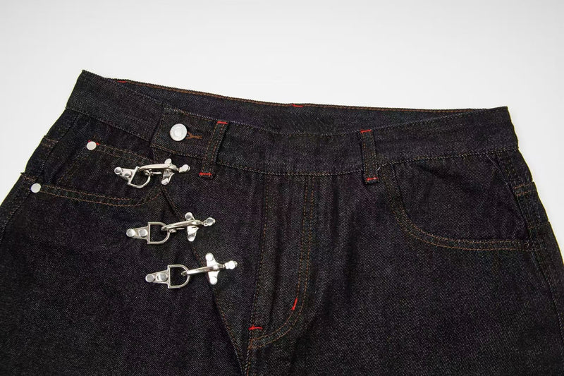 Close-up of front waistband and hook closures on dark wash denim pants