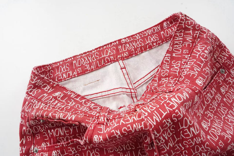 Close-up of red script print pants waistband with open top edge and interior lining