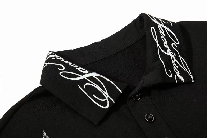 Black polo tee with white signature print on collar and sleeves, featuring a button placket and streetwear style