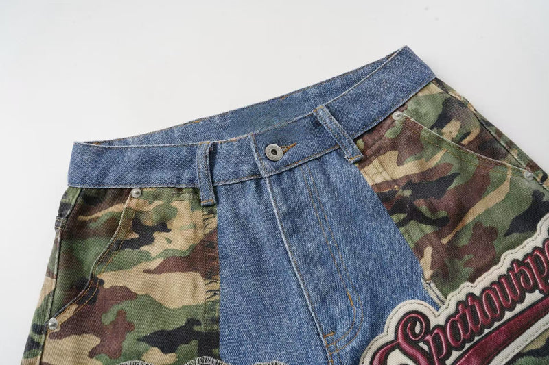 Angled close-up of the upper front waist on denim jorts with camouflage side panel