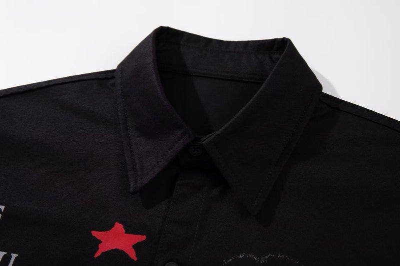Close-up of a black button-up shirt collar with red graphic print on the chest, streetwear style
