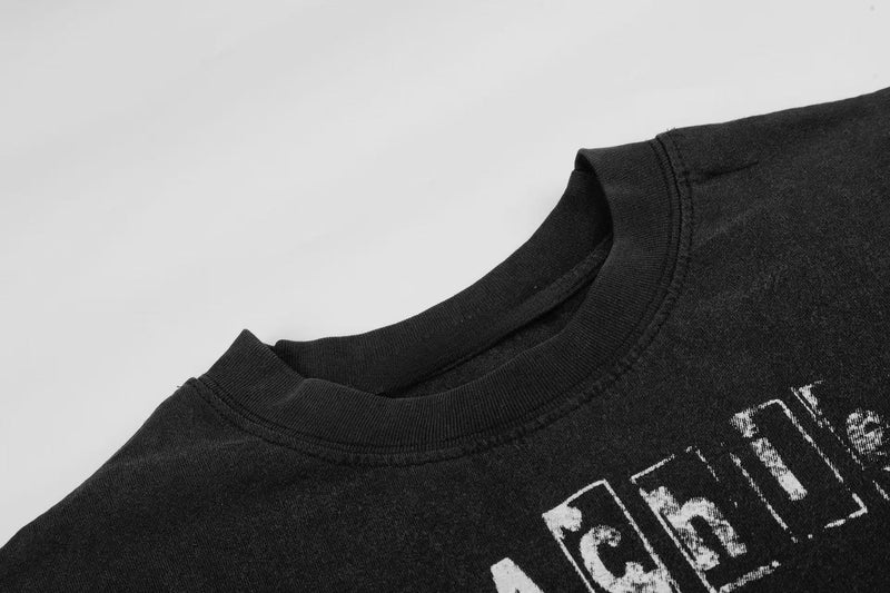 Black vintage graphic tee with worn white distressed print and ribbed crew neckline on a light background
