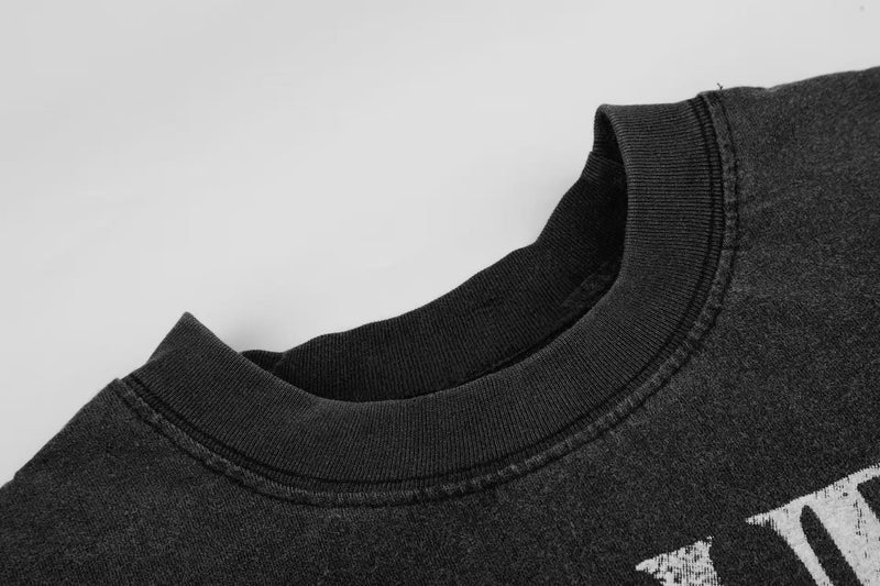 Washed black crewneck tee with faded cross graphic and vintage distressed streetwear style