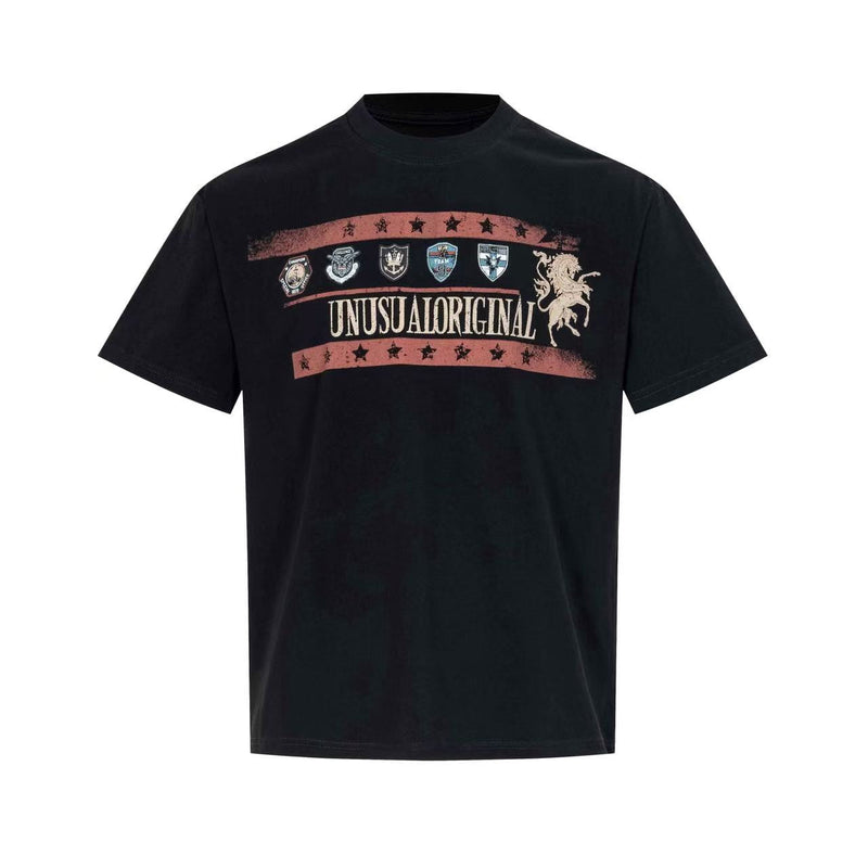 Black vintage graphic T-shirt with crest patches, star bands, and bold Unusual Original text across the chest