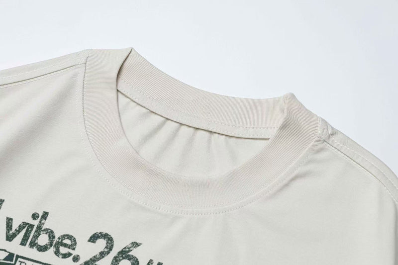 Close-up of an off-white vintage graphic tee with ribbed crew neck and faded punk band print on the chest