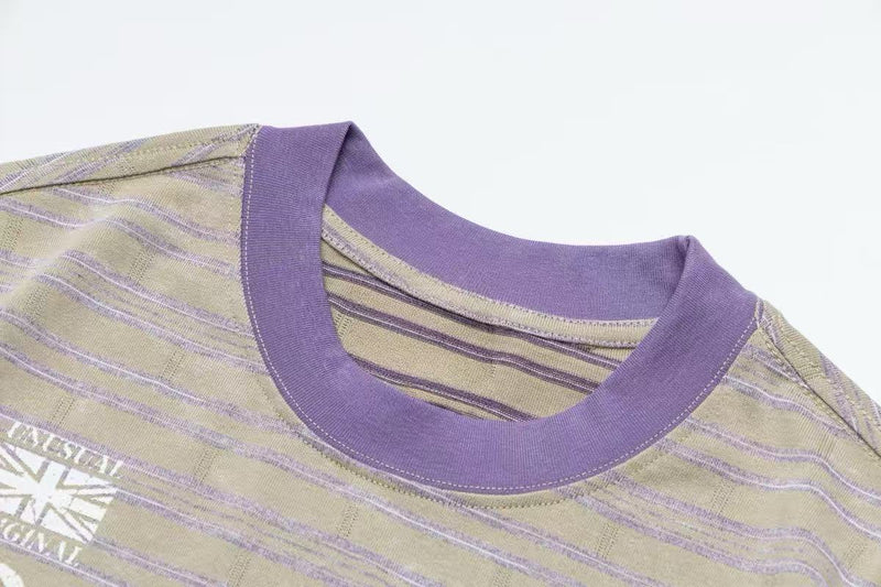 Vintage striped ringer T-shirt with purple collar and faded beige lavender stripes, laid flat on a white background