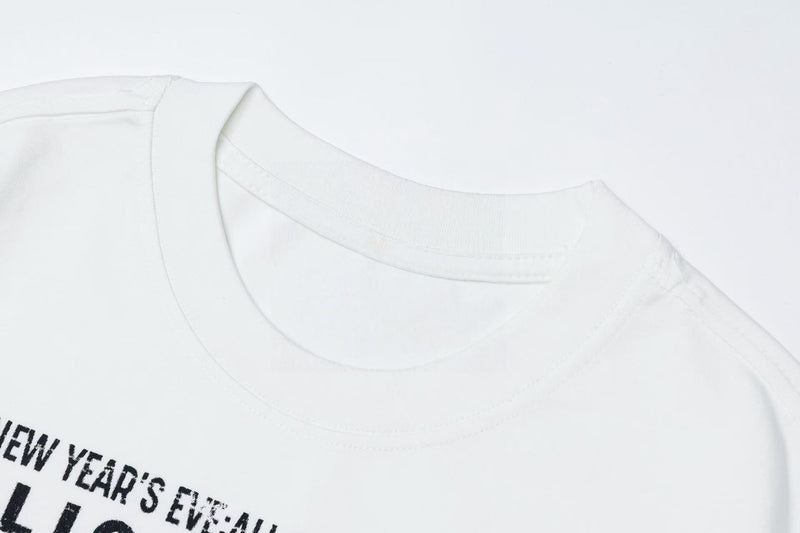 White graphic tee with a retro New Year’s Eve print and visible crew neckline on a clean background
