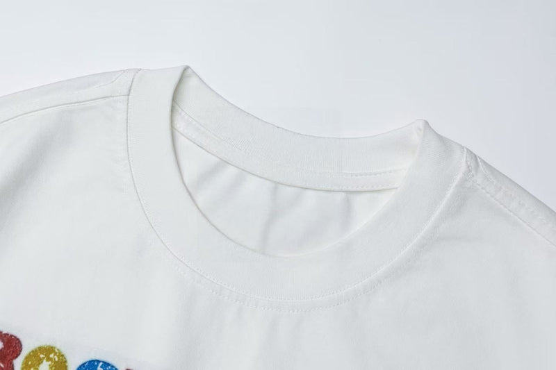 White graphic tee with a vintage rock collage print and ribbed crew neck detail