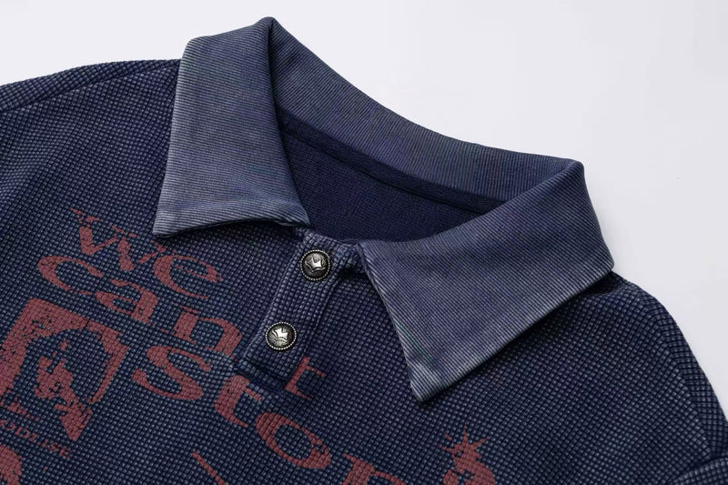 Navy vintage washed graphic polo tee with textured fabric, button placket, and retro red lettering on the chest