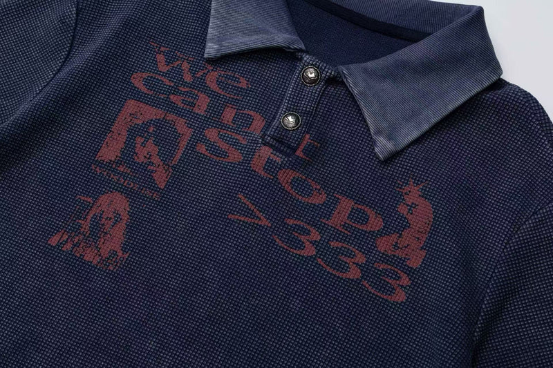 Navy vintage washed polo tee with faded red graphic print, textured fabric, and buttoned collar close-up