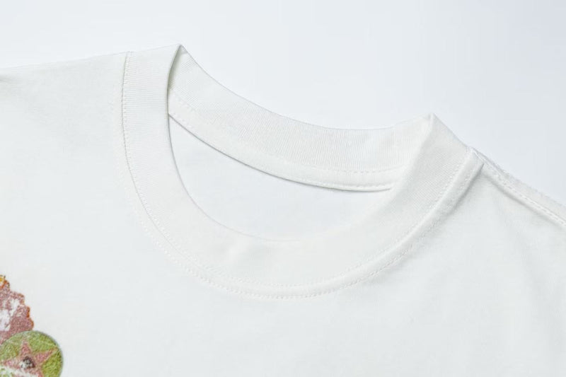 White crewneck graphic T-shirt with a faded vintage collage print and retro rock streetwear style