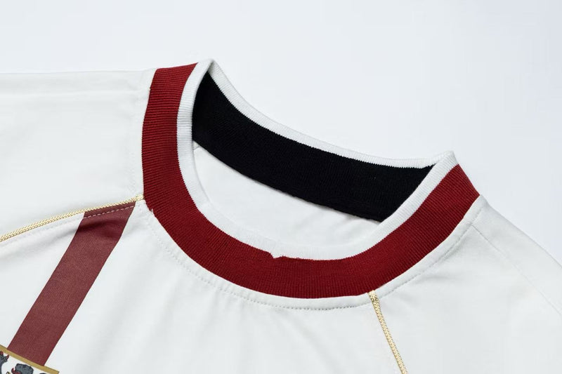 Close-up of a white retro football jersey tee with burgundy ribbed collar, black inner neckline, and vintage crest detail