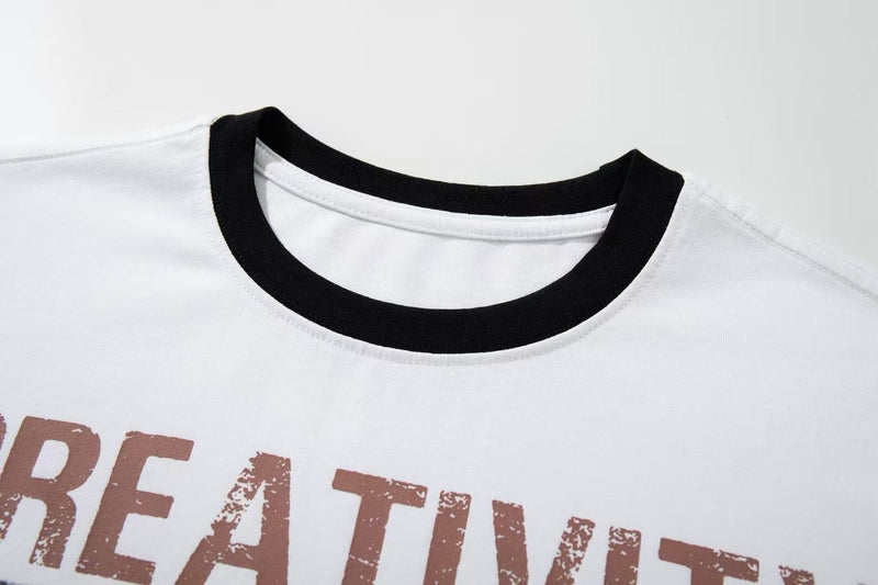 White ringer T-shirt with black collar and distressed creativity graphic text in retro vintage style