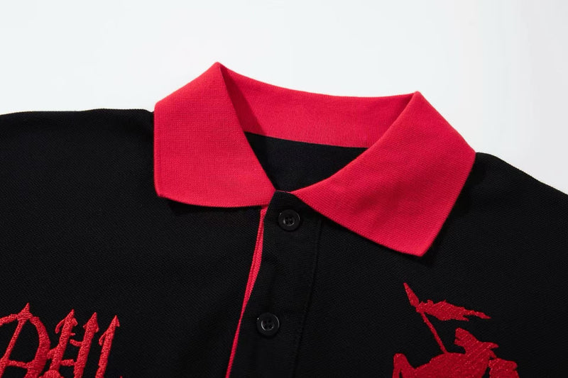 Black oversized polo tee with bright red collar, button placket, and gothic red graphic embroidery on the chest