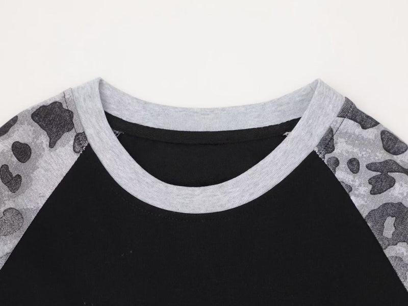 Close-up of gray ribbed crew neckline on black raglan leopard print tee