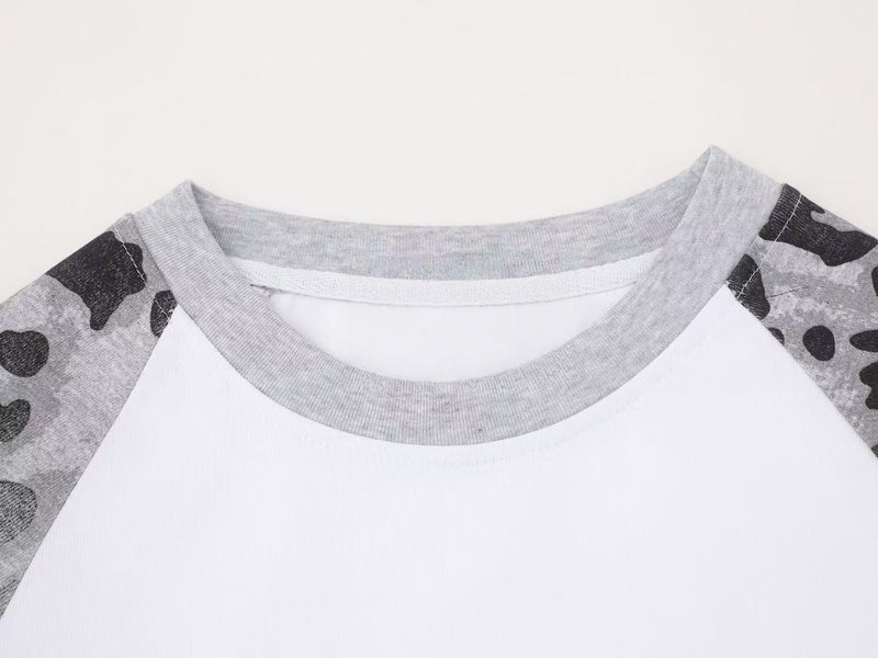 Close-up of gray crew neckline and shoulder seams on white raglan tee