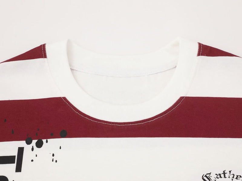 Close-up of an oversized striped graphic tee with burgundy and white bands, black splatter print, and a ribbed crew neck