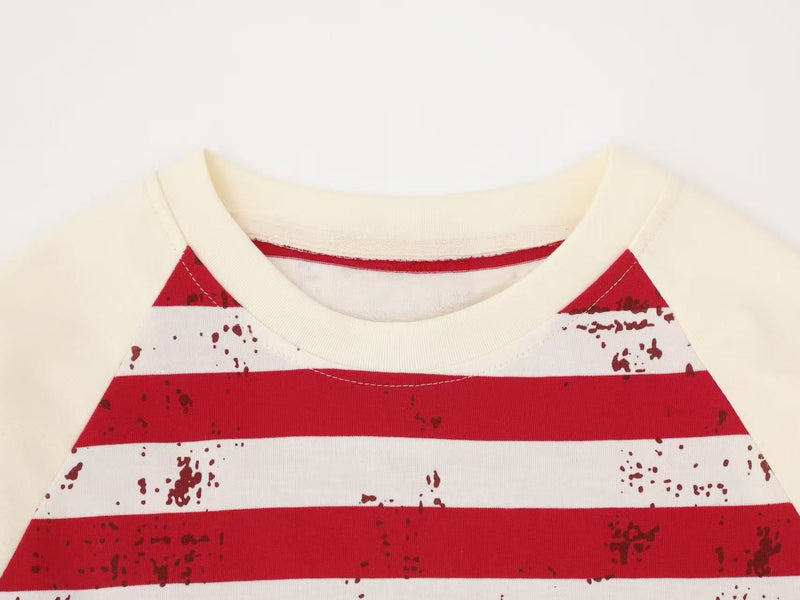 Close-up of cream tee collar and red stripes with raglan sleeve seam
