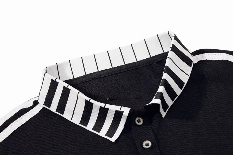 Black polo shirt with white striped collar and buttons, featuring a vintage music script streetwear style