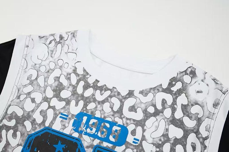 White sleeveless graphic tee with gray leopard mesh print and blue varsity-style lettering on the chest