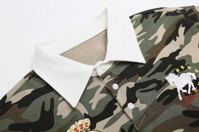 Camo polo shirt with white collar and embroidered horse and stars on a green, black, and beige camouflage pattern