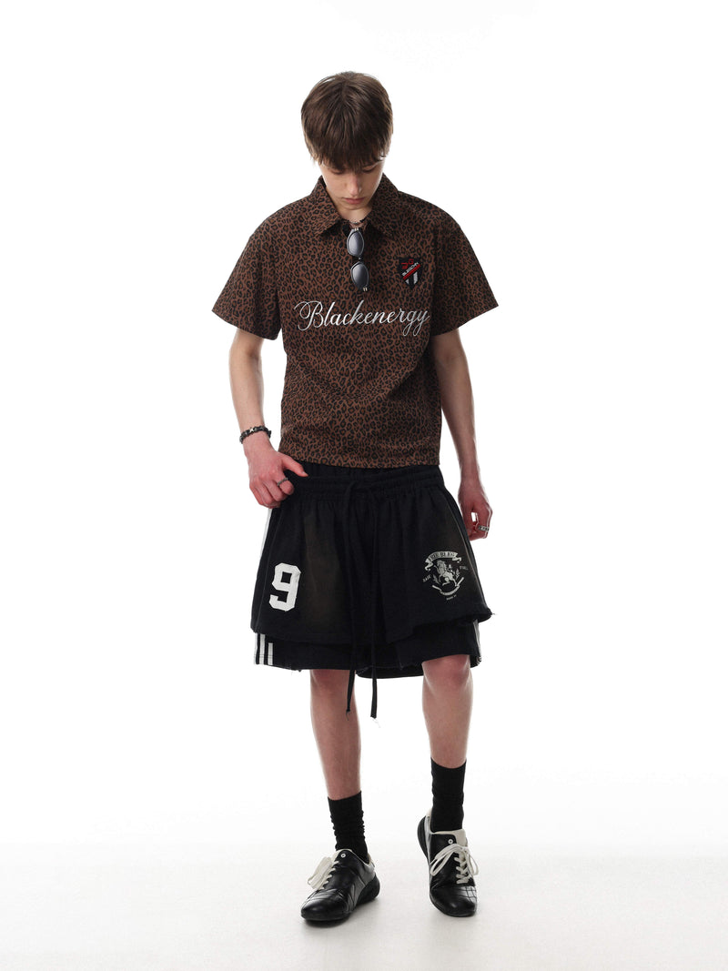 Brown leopard print polo tee with script logo and short sleeves, styled on a model with streetwear shorts and black shoes