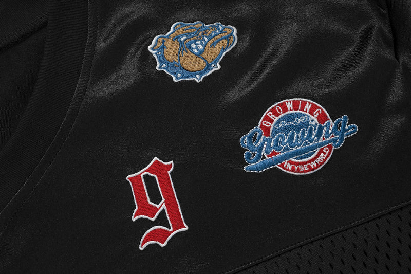 Black patchwork mesh football jersey tee with embroidered graphic patches and bold streetwear detailing