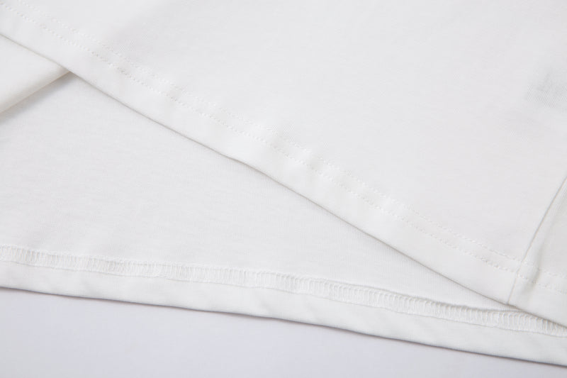 Close-up of white tee hem stitching and side seam