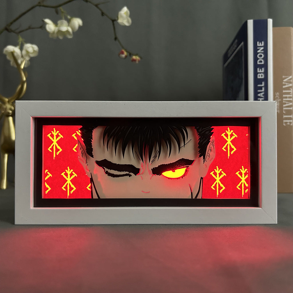 The Berserk Anime Light Box – Guts (The Black Swordsman) features a character with an intense gaze and eye patch against a red backdrop with glowing symbols, accented by a floral branch and books, enhanced by 16-color adjustable LED lights for a 3D effect.