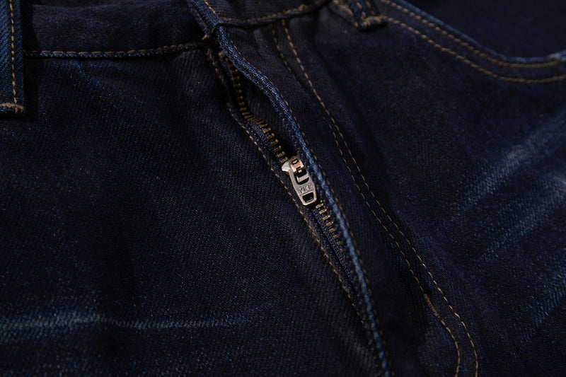 Close-up of the front zipper fly on deep indigo denim jeans