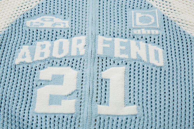 Close-up of light blue back lettering and chest logo details on mesh knit jacket