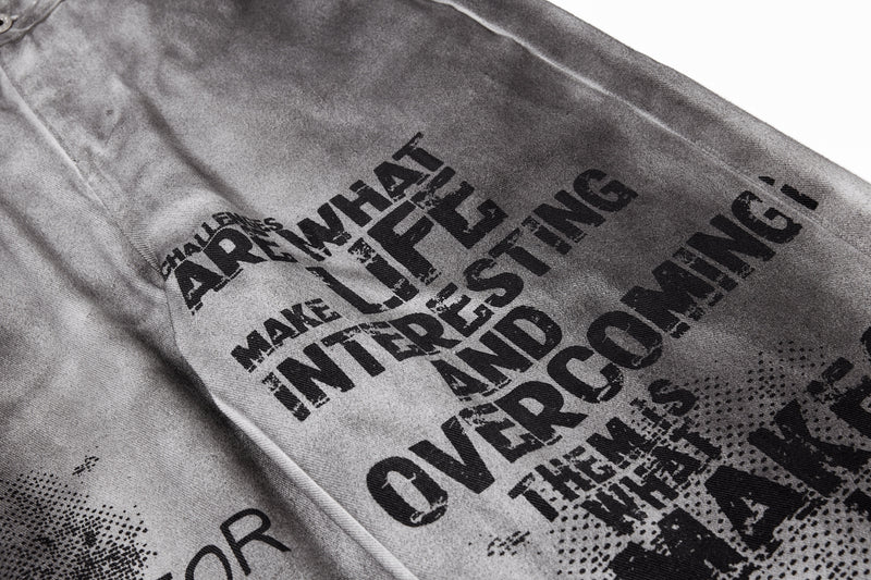 Close-up of front leg graphic text and halftone print on gray washed denim