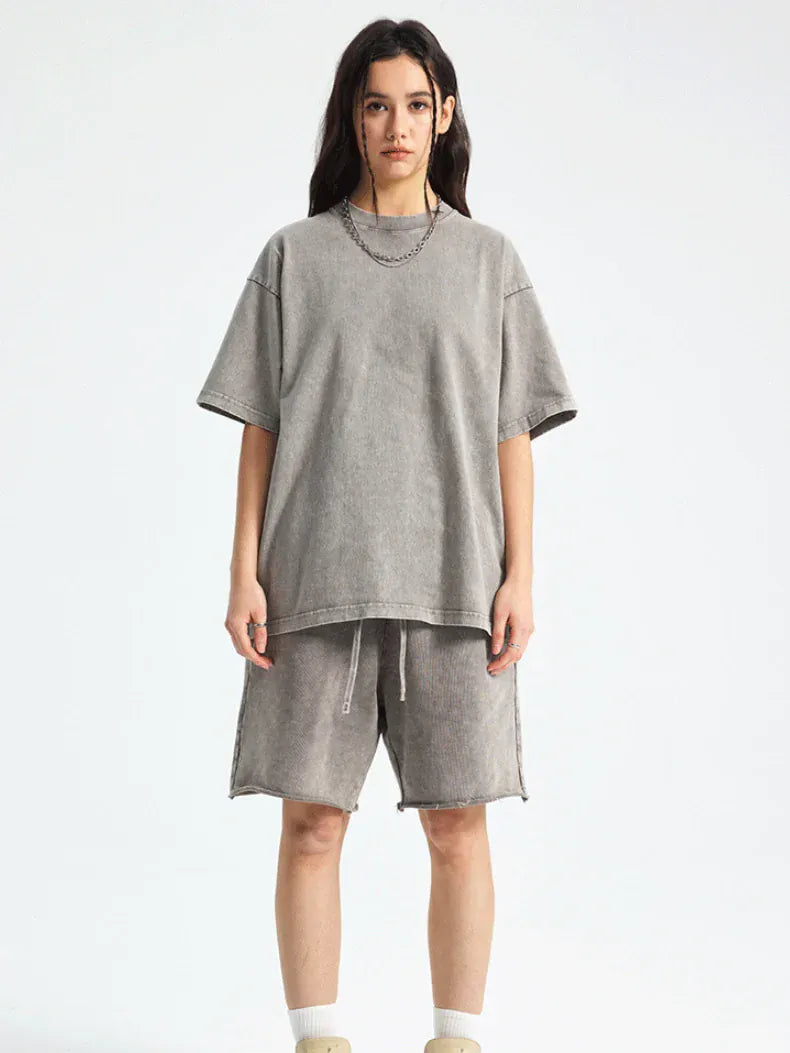 Person facing forward against a plain white background, wearing an oversized Custom Anime Character Gray Washed T-Shirt - Personalized Anime Style Tee, matching gray shorts, beige socks, and a chain necklace.