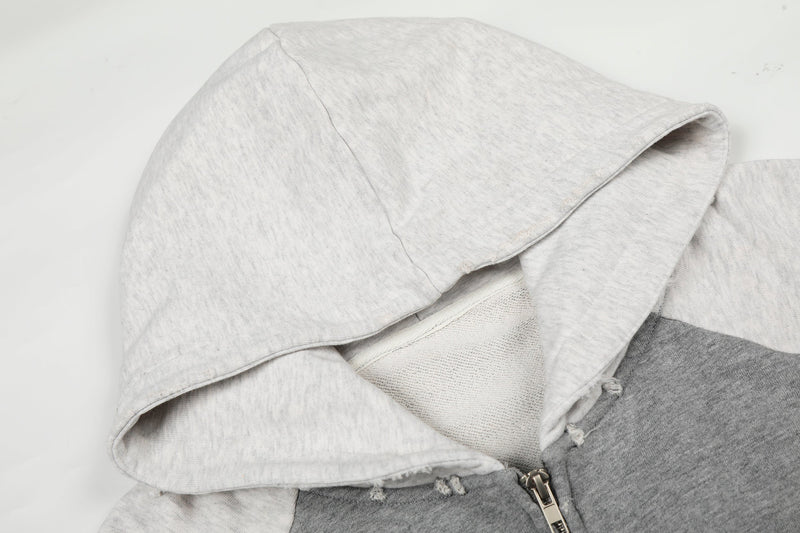 Close-up of white hood and fleece lining on a distressed gray and white zip-up hoodie