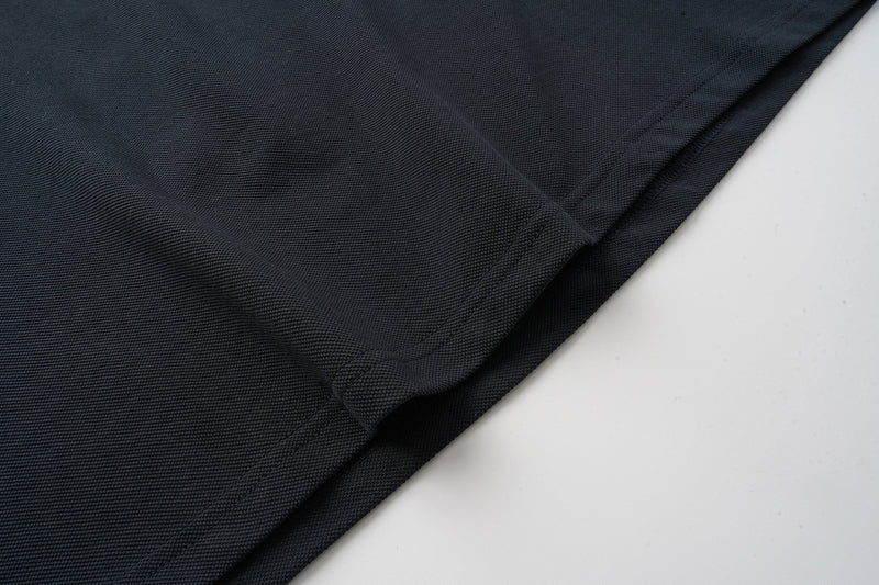 Black shirt hem close-up with smooth knit fabric and stitched seams
