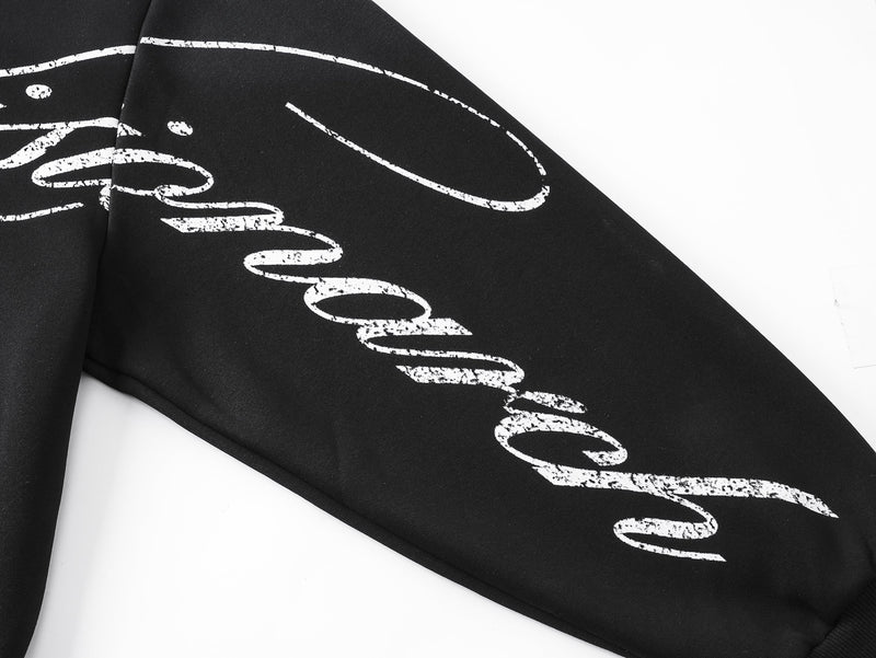 Close-up of black sleeve with white script lettering across the arm