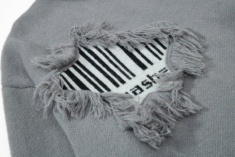 Gray knit sweater close-up of upper fringe patch with striped graphic