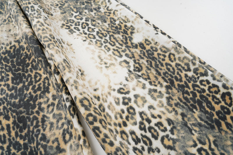Close-up of wide-leg leopard print fabric draped over the pants leg